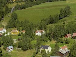 Småhusbebyggelse. Dyrka mark bak. Liten hoppbakke t.v.