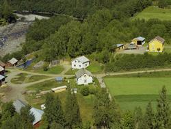 Follebu Bruk. Sagtømmer. Materialstabler. Flere bolighus. El