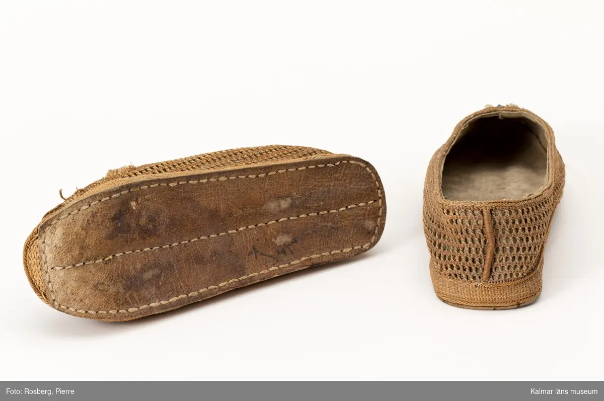 KLM 44626. Skor, ett par. Kinesiska skor av flätverk (rotfibrer) med broderier framtill. Tjock sula, läder.