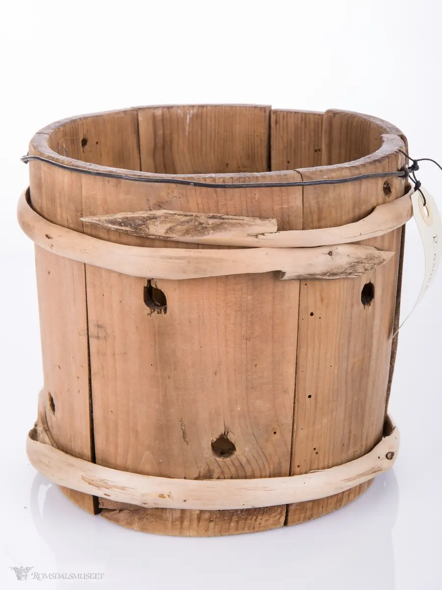 Lagget av 6 staver som har 2 hull i hver. Gjennomhullet bunn med kors og 4 hull. Hank av streng festet med . Gjordet oppe og nede.