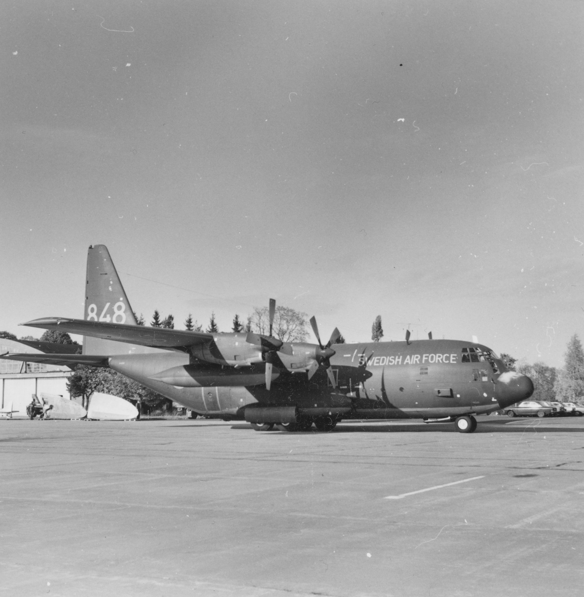 Urlastning av flygplan TP 84 nummer 848 på flygfältet framför en hangar på F 3 Malmen. Flygplanet har ett flygplan Spitfire som last, vilket har anlänt till Flygvapenmuseum från Kanada.
