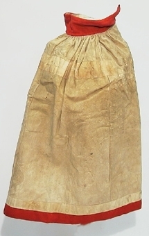 Kjol i skinn med pälssidan inåt som är sydd i fyra våder med rött kläde i linning och nertill.