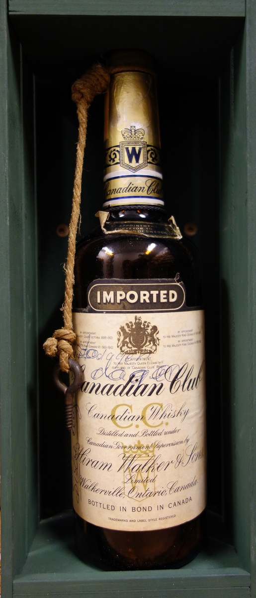 Whiskyflaska av märket Canadian club. Märkt "sista dykdagen". Flaskan har ett rep samt en krok runt halsen.