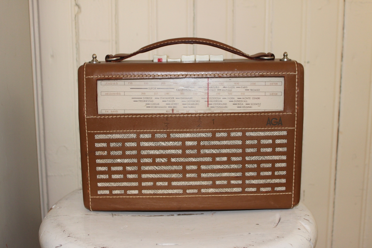 Transistorradio i läder med vita plastknappar och metalldetaljer. Två antenner i metall. Märkt "AGA" på framsidan. På baksidan "AGA Transistor 3514". På undersidan finns en klisterlapp med nummret "531660".