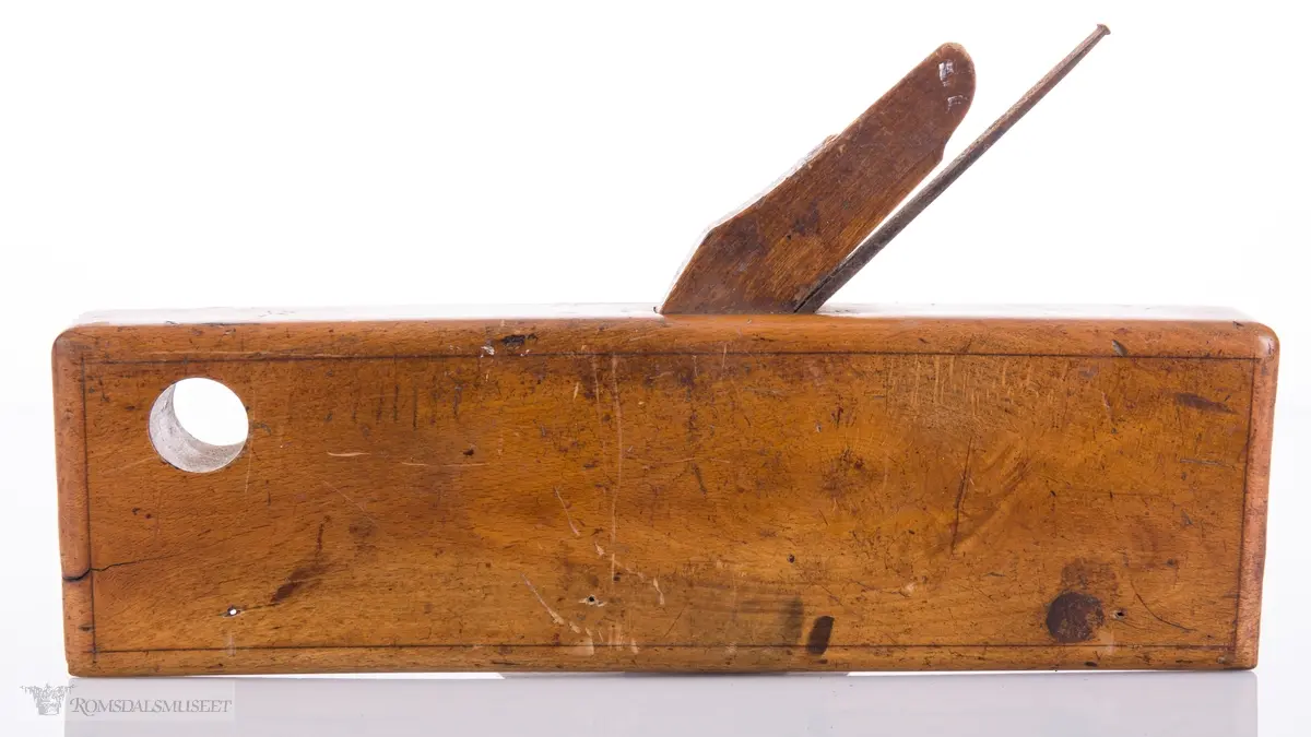 Smal høvel med hesteskoformet jern for høvling av fjær. Den ene siden av høvelen har en støtteskinne.