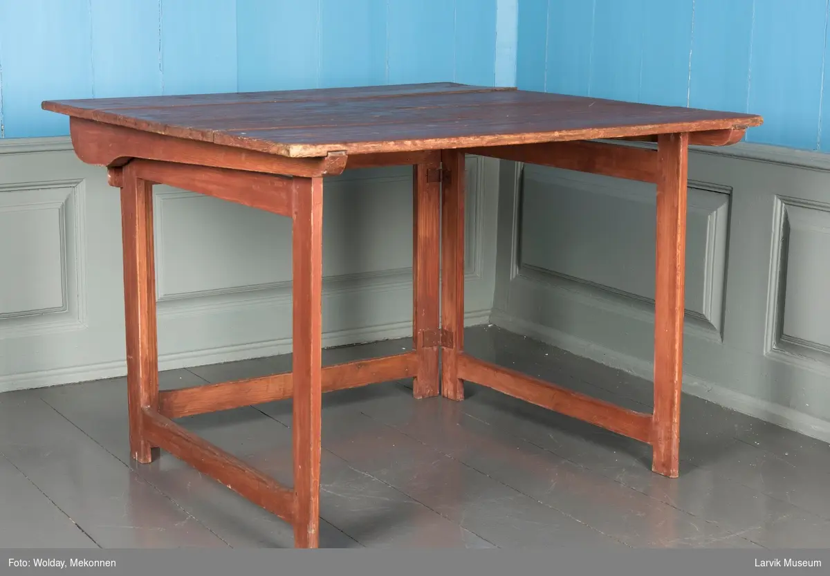 Sammenleggbar bord med rektangulær form. Bordplate sammensatt av 4 brett, hviler på tre rammer, hengslet, siderammer slås inn mot rammen bak. Rammen bak tappet inn i sarg, platen kan slås ned.