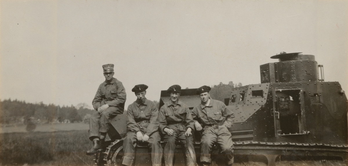 Fyra män sittande på stridsvagn m/1921 (eller m/1921-1929). Göta livgardes stridsvagnsbataljon år 1929.