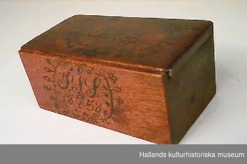 Skrin av trä till förvaring av pengar. "1858, J J S 18 18/1 58". Märkning: Sista bokstaven tolkas också som J.