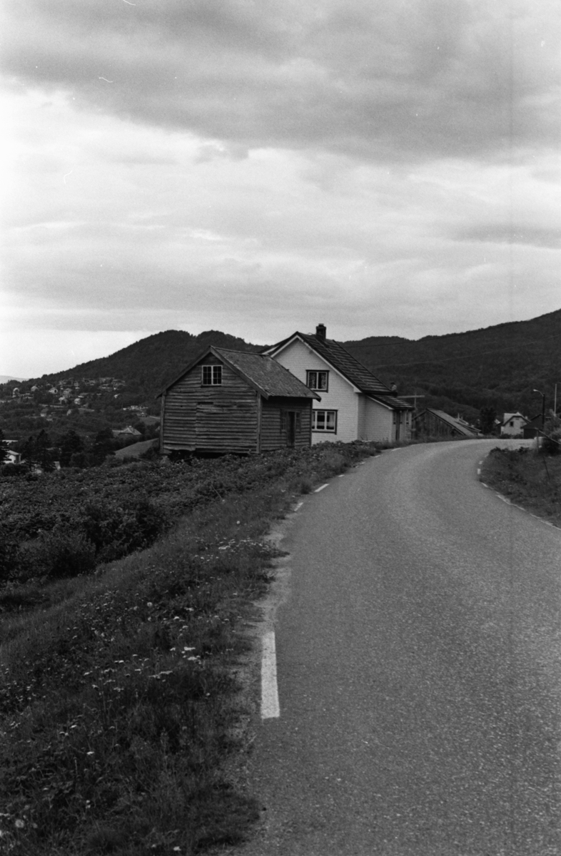 Stabbur som tilhører Øygarden, Vatne. I bakgrunnen en annen bolig.