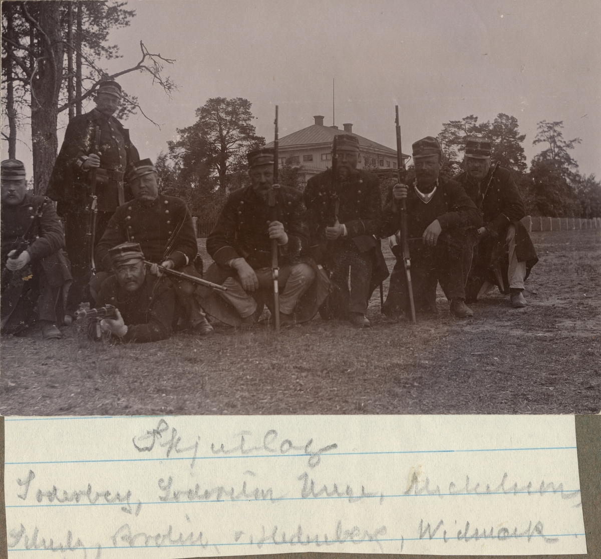 En grupp soldater vid Hälsinge regemente med sina gevär uppställda för gruppbild. Enligt bildtexten utgörs skjutlaget av: Söderberg, Södersten, Unge, Michelson, Schultz, Brolin, von Hedenberg, Widmark.