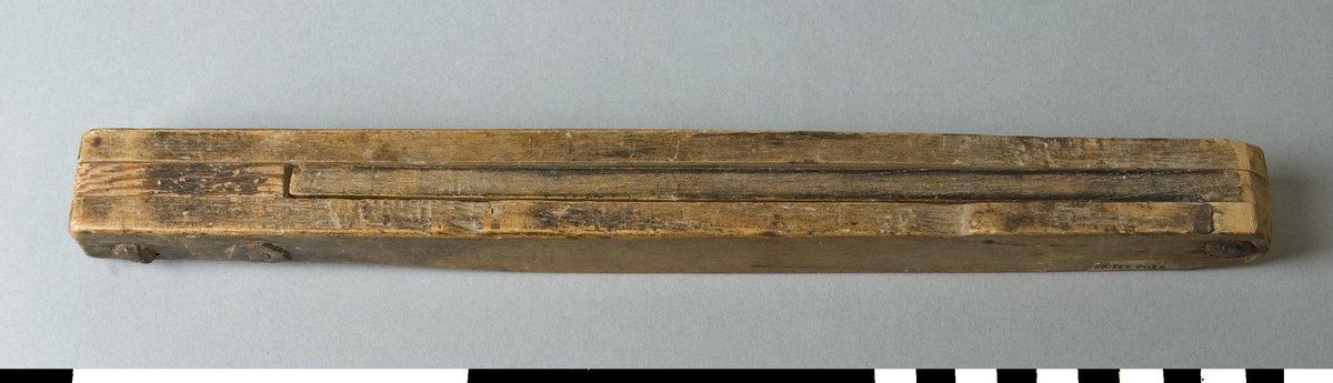 Smygvinkel av trä. Den består av två fasta parallella trästycken som är förbundna med varandra i vardera änden med skruv. Mellan dessa finns en ställbar vinkel som kan ställas i önskad vinkel. Vinkeln är ej låsbar.
Skruv och mutter är rostiga.


Funktion: Mätning och markering av vinklar, inställbar