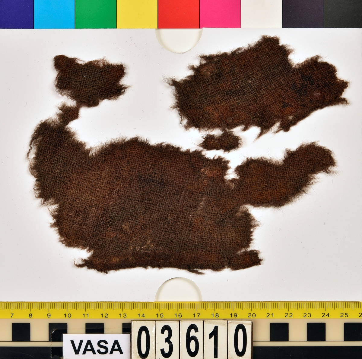 Textilfragment. Tre stycken fragment av ull vävt i tuskaft.
Fyndnummer 03610b är ett läderfragment.