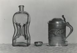 Motiv av ei knipflaske (klunkflaske), en tomling av sølv og 