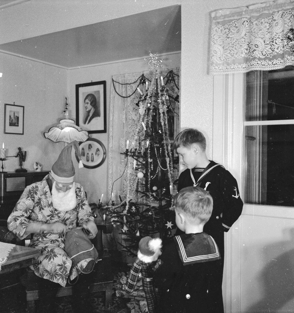 Gutar får gåver av julenissen i ein heim på Egne Hjem julaftan.