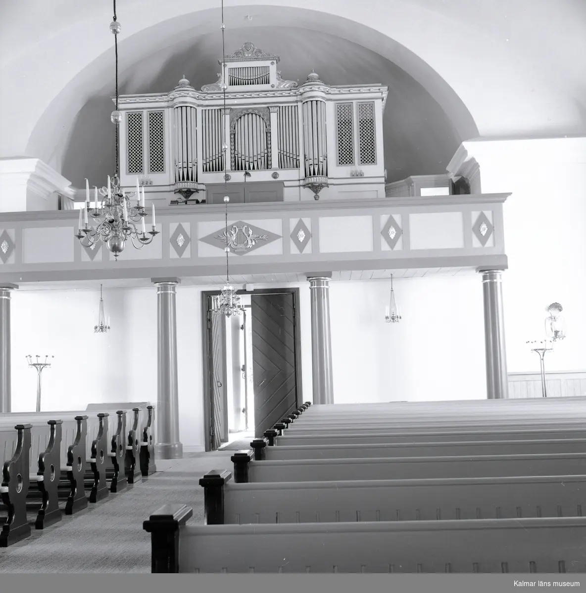 Interiör med orgelläktare och kyrkbänk i Gamleby kyrka.