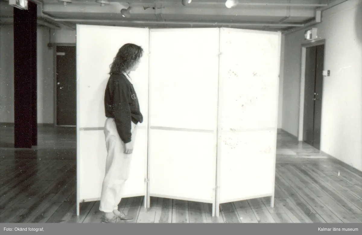 En kvinna vid en skärm i en utställningslokal.