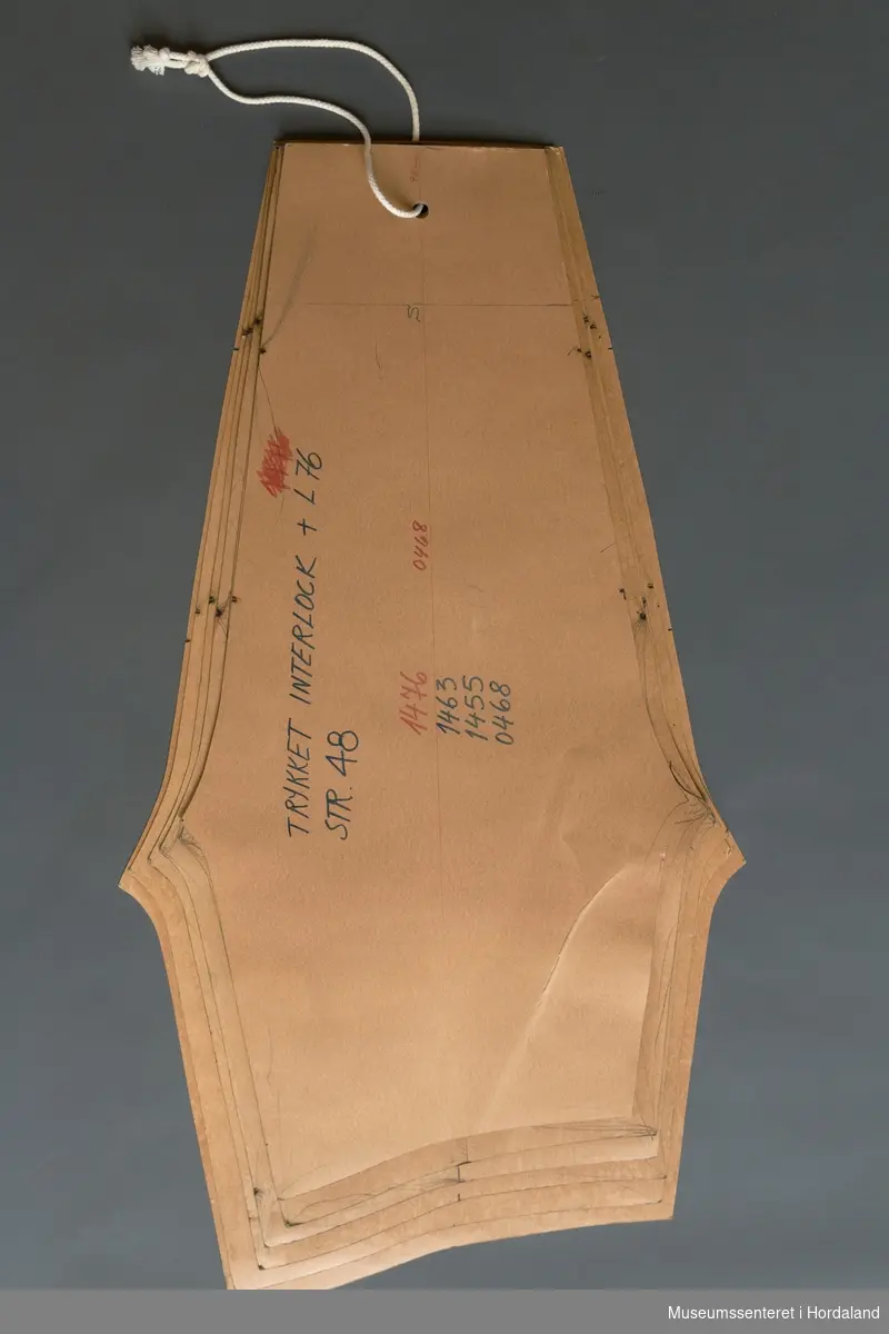 Mønsterskantar i papp, brukt til å skjere ut ulike delar av plagg i klesproduksjon. Desse er truleg til bukser i påtrykt interlockstoff og kvalitet L 76. Art. nr. 1476, 1463, 1455, 0468.