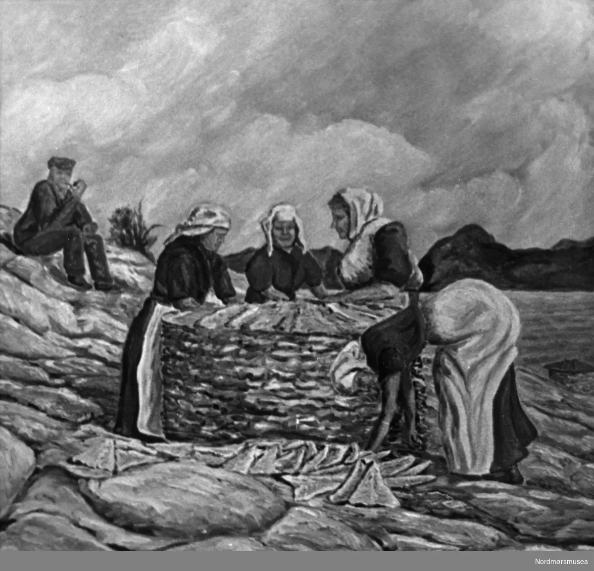 Maleri av fire kvinner som stabler klippfisk i la på tørkebergene i Kristiansund, mens en oppsynsmann sitter og røyker pipe i bakgrunnen. Kunstner er H. Stokstad. Dateres trolig til 1930-årene. Fra Nordmøre museums fotosamlinger.