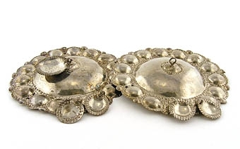Bröstbucklor av silver med runda, skålformade blad.