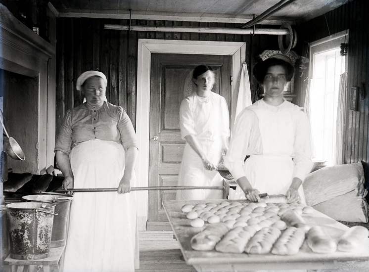 Tre kvinnor bakar bröd.