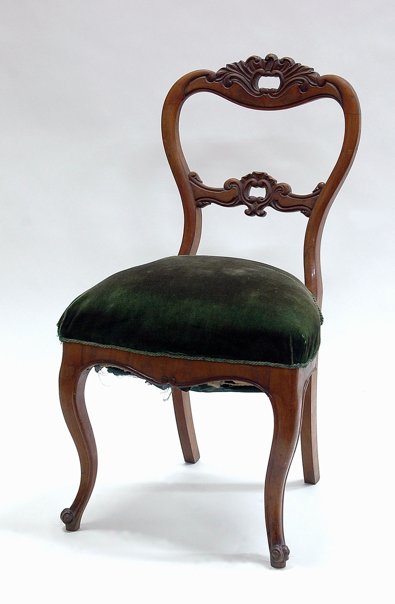 En av sju st stolar, av mahogny, sits klädd med schagg.