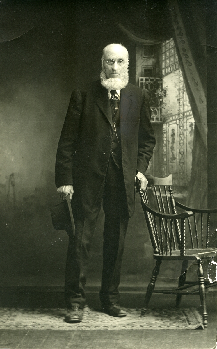 Mann stående ved stol m/hatt i hånden. Portrett av *Jon Aasen (1840). Bilde fra USA.