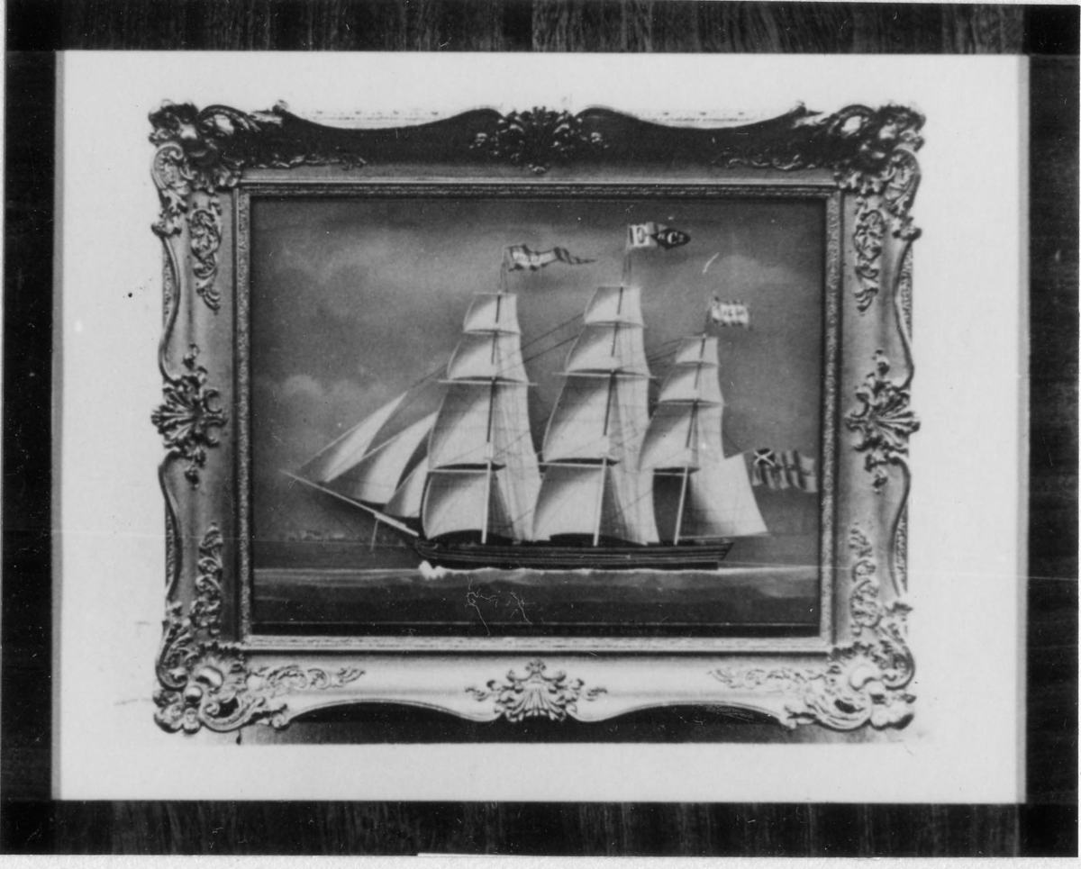 Fotografi av målning i glasmålningsteknik. Skeppet AUDACIA med alla segel satta, visande babords sida. Till vänster konturerna av en stad, Vlissingen.