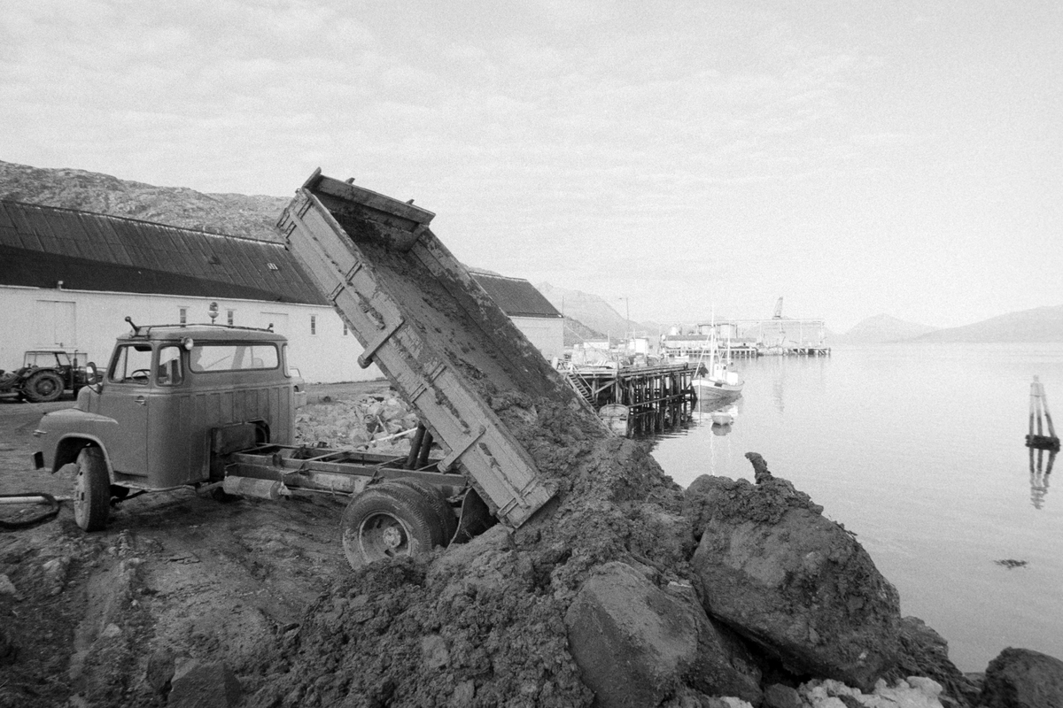 Lastebil tipper masser ut i sjøen i forbindelse med anleggsarbeid i Lødingen.