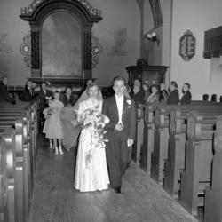 Foto fra et bryllup, hvor vi ser fra kirken, med brudeparet 