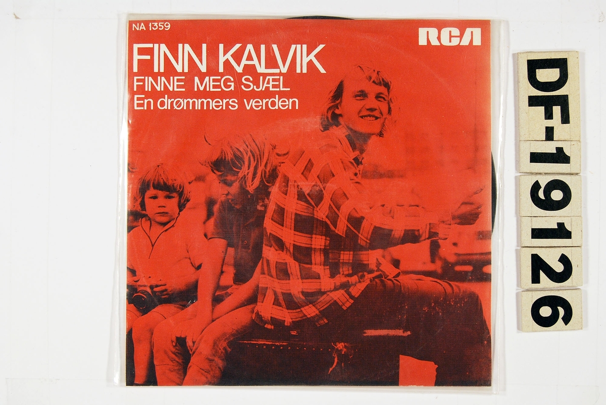 Bilde av Finn Kalvik sittende ved siden av to barn.