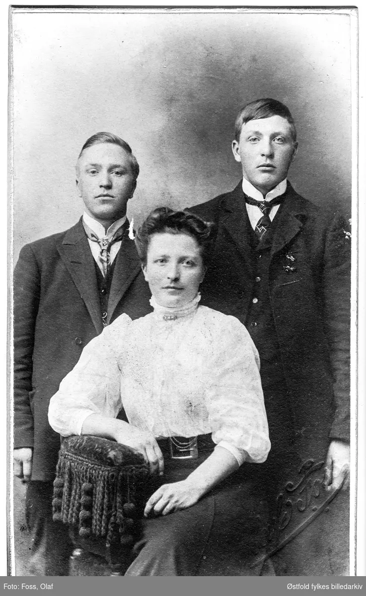 Portrett i atelier av ukjent kvinne og to ukjente menn, visittkort, ca. 1893-1905.