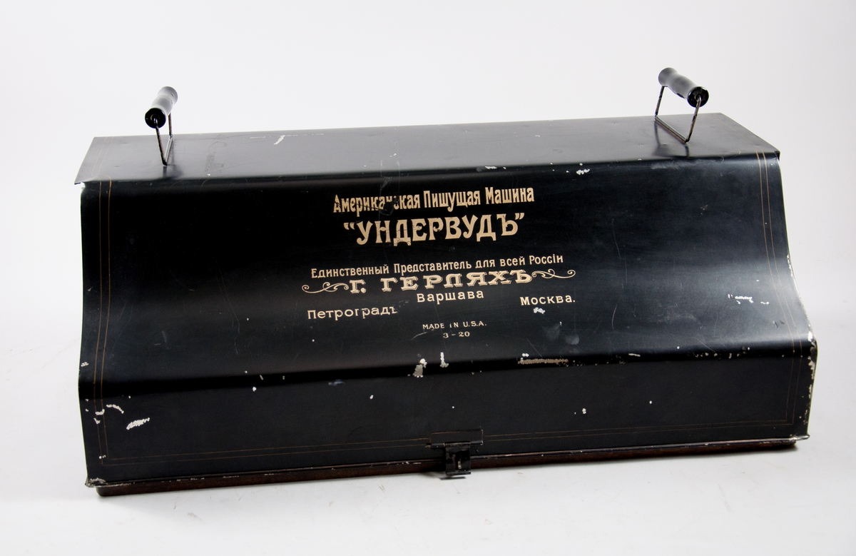 Skrivmaskin Underwood Standard Typewriter No. 3, 20 inch bredd.
Märkt med adress för Underwoods återförsäljare i Petrograd, Moskva och Warszawa. 
Svensk teckenuppsättning, med å, ä och ö.
Monterad på träplatta, med huv av plåt.
