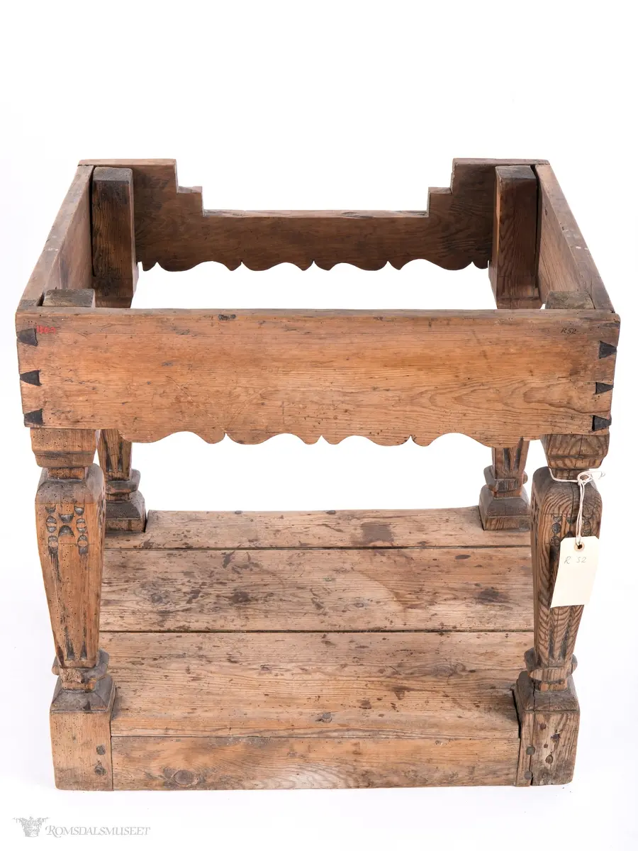 Platen hviler på arkitrav som igjen hviler på koniske pillarer med en form for kannelering med kapitel/terningkapitel og basis. Alt hviler på postamentet med høyde 12 cm.