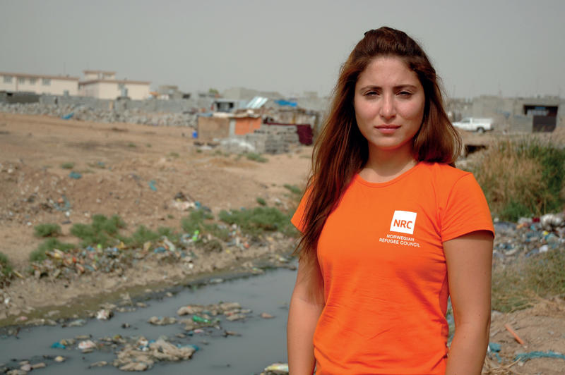 Becky Bakr Abdullah, medierådgiver for Flyktninghjelpen, står foran en flyktningleir