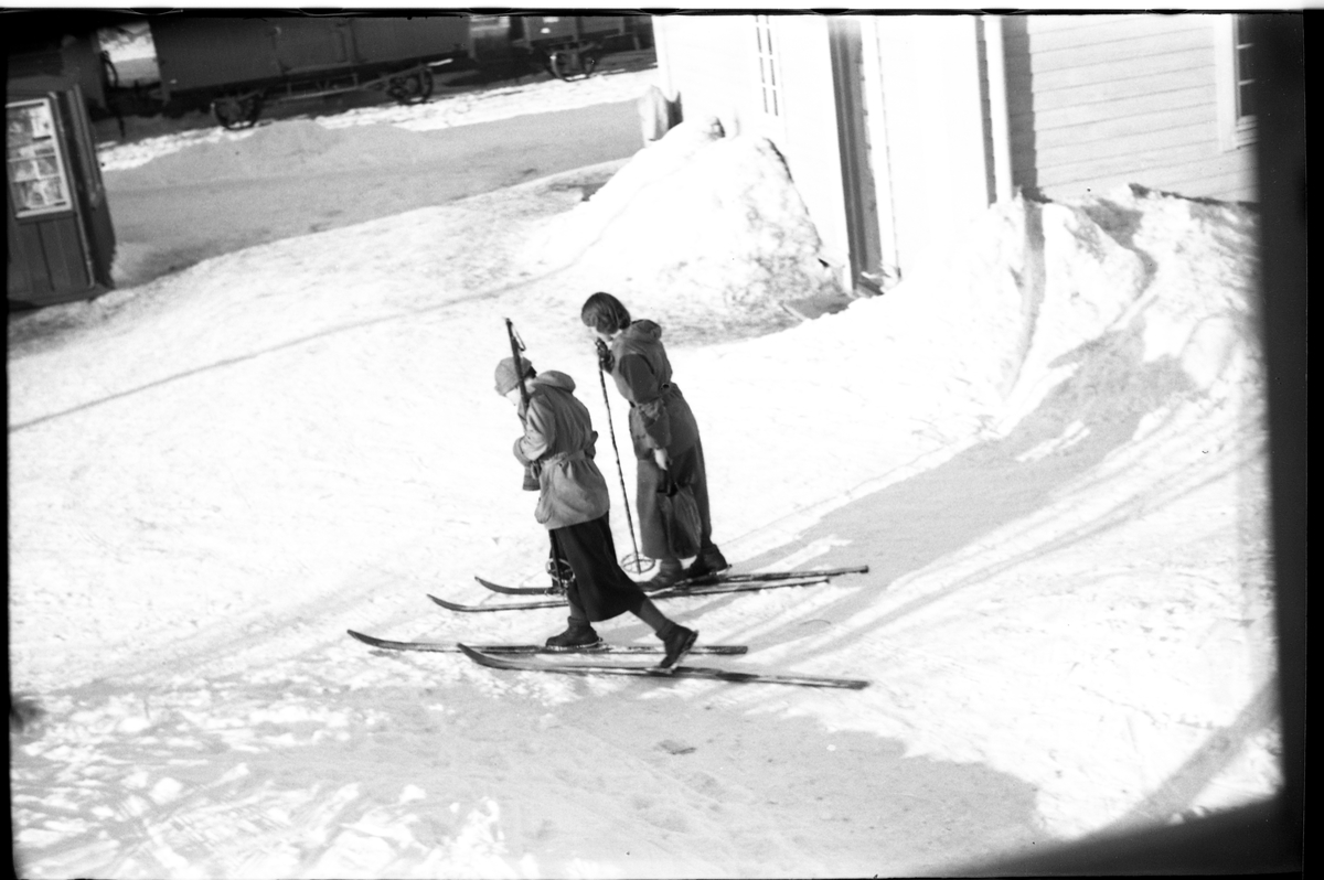 To uidentifiserte unge jenter på ski utenfor Lena stasjon.