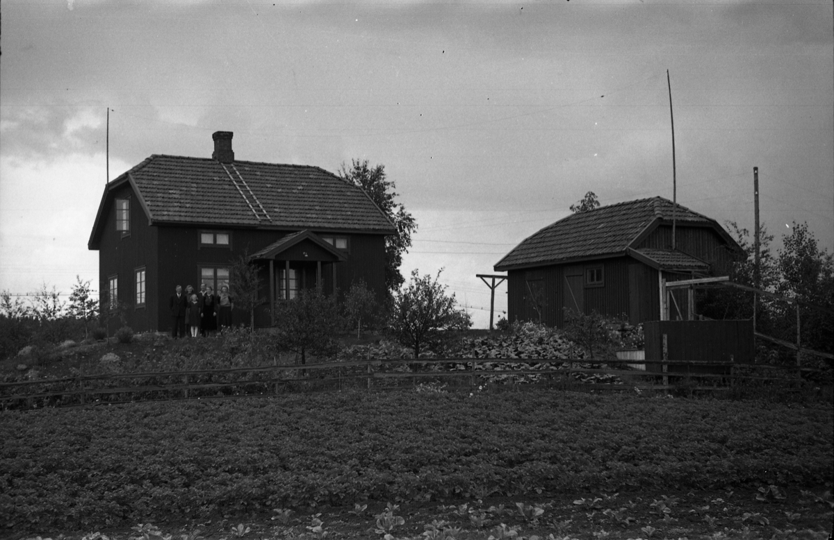 Ingar og Jeanette Tallerud med barna fra venstre Judith, Ivar, Minnie og Dagny foran bygningen på hjemstedet Bergheim på Kraby, Ø.Toten..