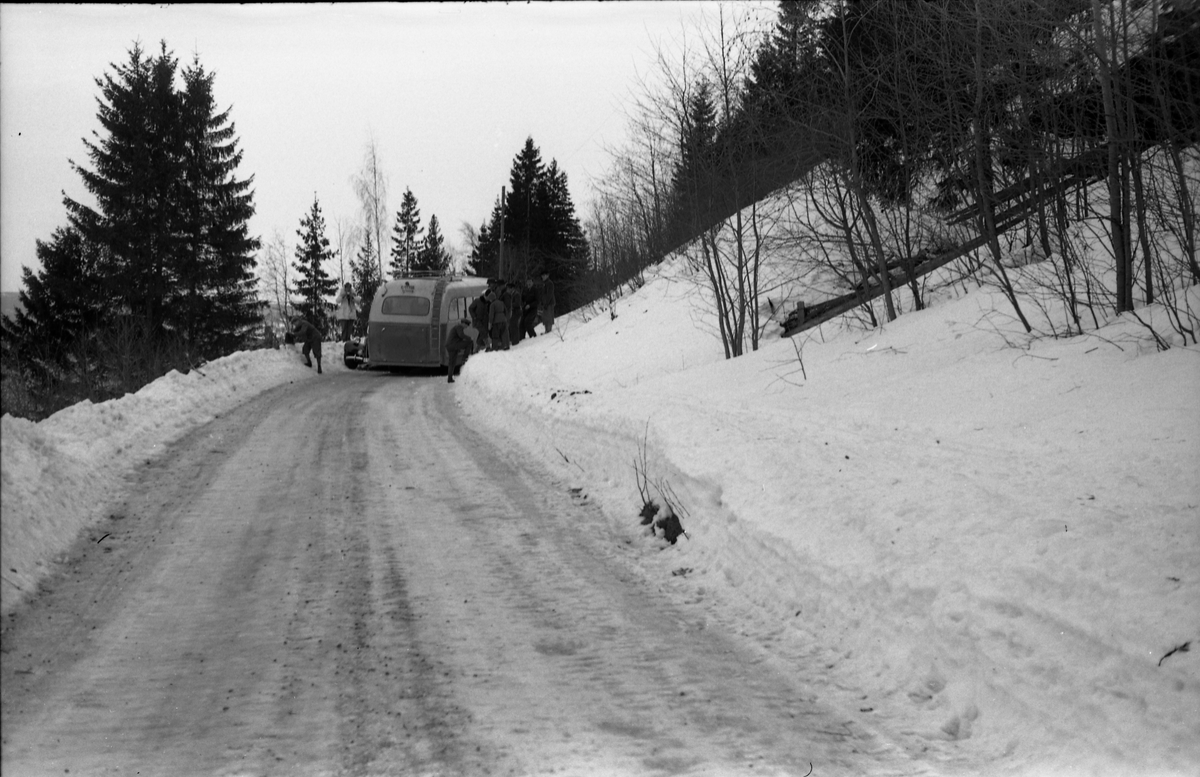 Møteuhell mellom buss og personbil på en trang Rv. 33 ytterst i Totenvika en vinterdag 1950. Bussen er "Eidsvollruta", bussen som gikk mellom Skreia og Eidsvoll. Serie på ni bilder.