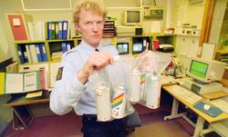 Fra venstre: To politibetjenter med spraybokser i poser.