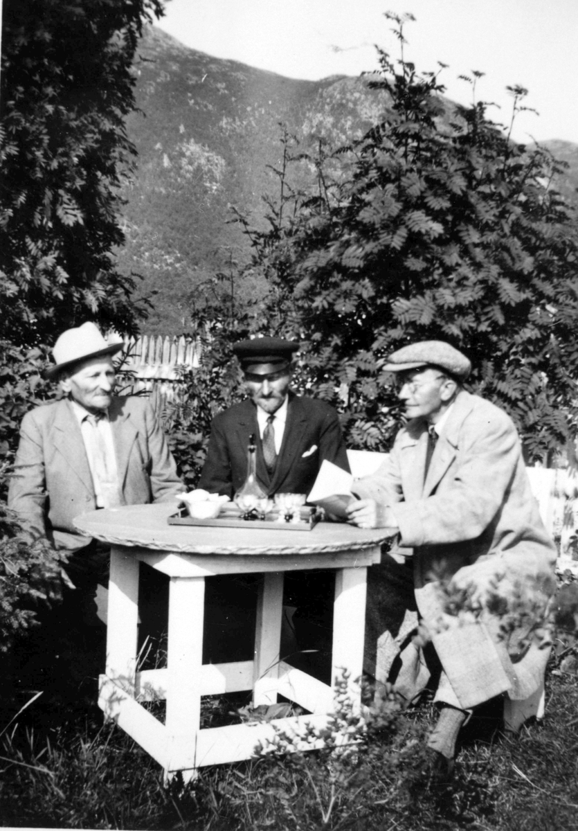 Tre menn rundt et bord. Daniel Hetmann Rochmann, Valvåg i midten. Tranøy.