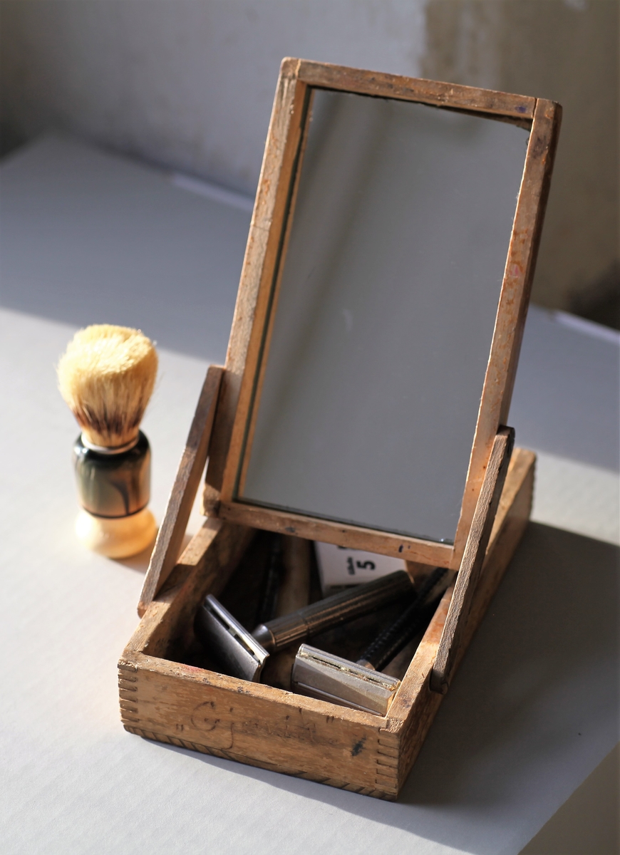 Treskrin med speil som inneholder barbersaker.
