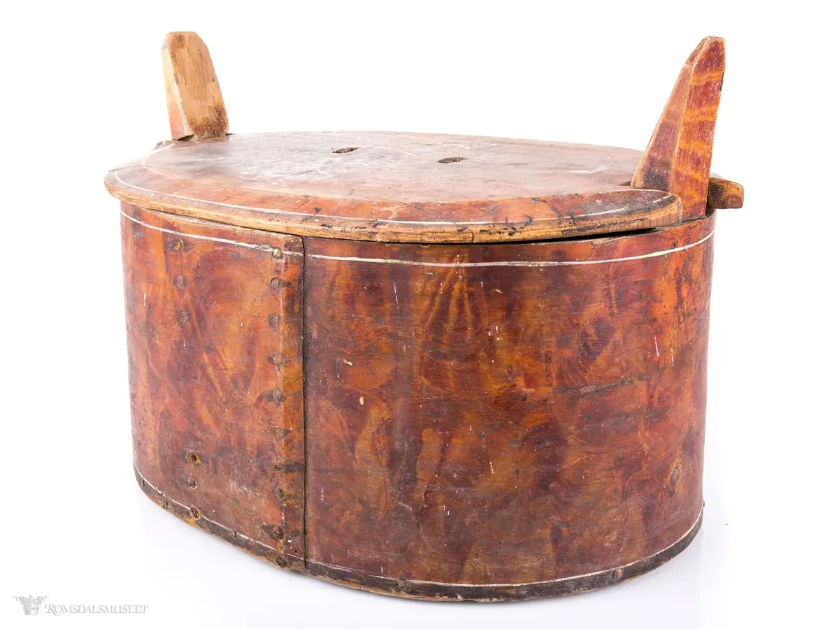 Hvite linjer langs kanten. Avrundet lokk. Innskrift.