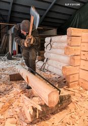 Tømrer Knut-Arild Nordli ryr en rå furustokk som skulle erst