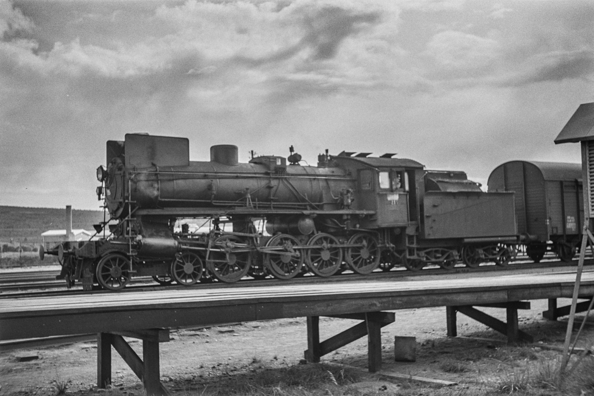 Damplokomotiv type 26a nr. 215 med sydgående godstog på Røros stasjon.