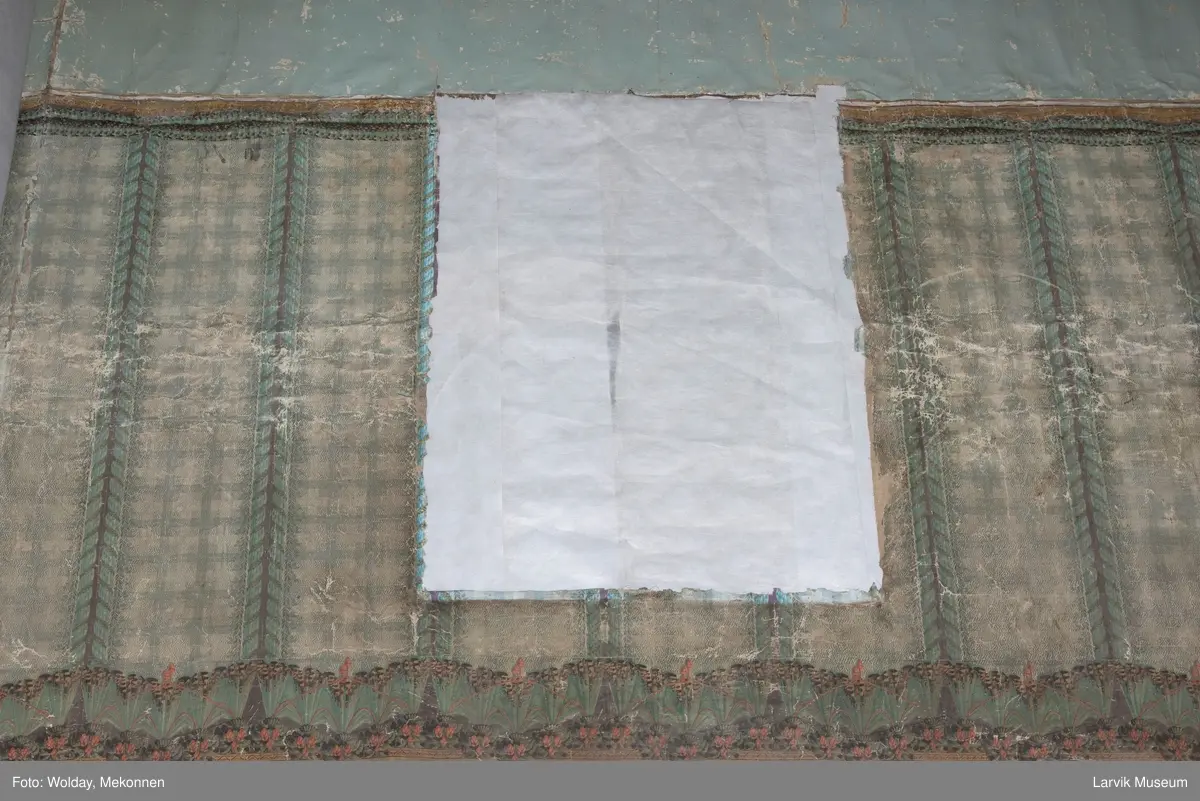 |Tapeten er påmalt tapetborder og brystning. Fra Hovland gård i Larvik.
Den øverste, brede borden: Gerlander/draperi med blomsterranker.
Den nederste, smalere borden: Tekstilbord med blomster. Øver døren til høyre: Stillebenmotiv med blomster og frukt.