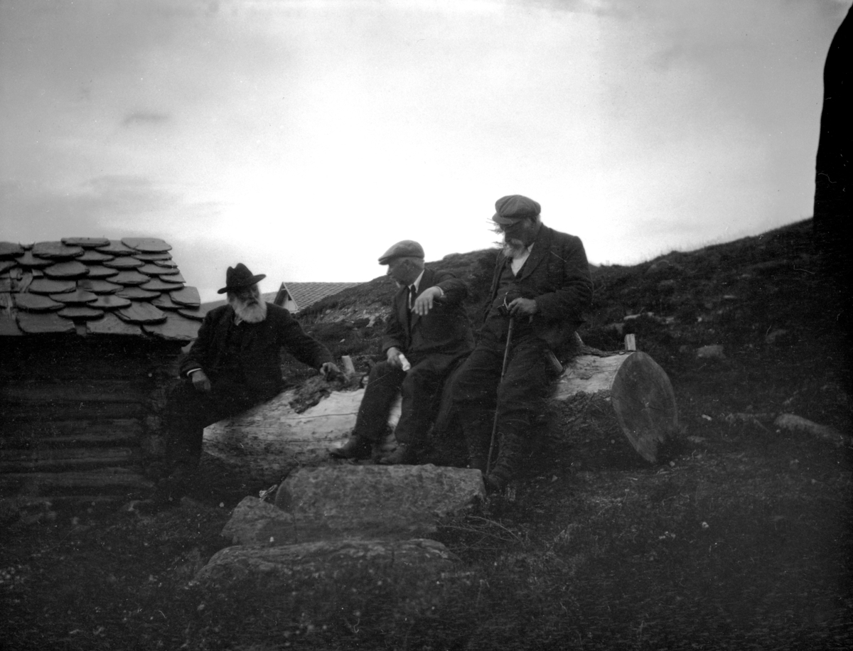 Johan Kjorstad og to menn sitter på tømmerstokk mulig i fjellet ved  Fron.