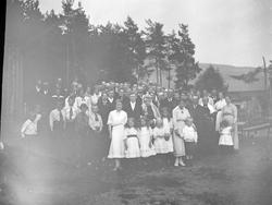 Bryllupsbilde tatt med brudepar og alle gjestene ute.