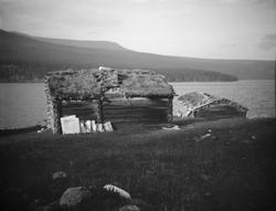 Gammel fiskebu med naust ved fjellvann.