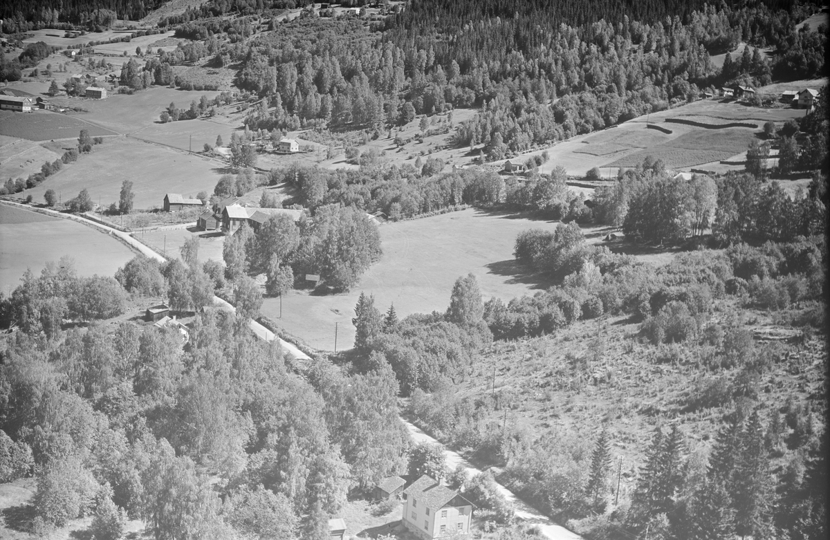 Kongsvegen sør for Tretten med Holmen gård i bakgrunnen. Huset i nedre bildekant, Holmbo, er revet. Huset nordenfor er Kongsvegen 1408