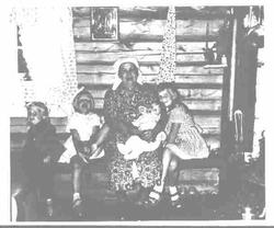 Eldre kvinne med mange smårollinger rundt seg