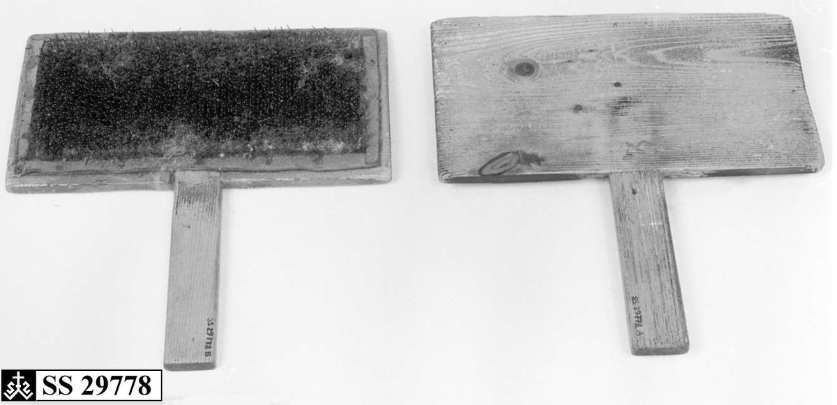 To treplater hvor innsiden av begge platene er dekket av en skinnduk med tettsittende nåler. Begge treplatene har håndtak.